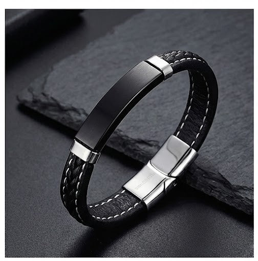Black leather bracelet with silver accents on a dark stone surface