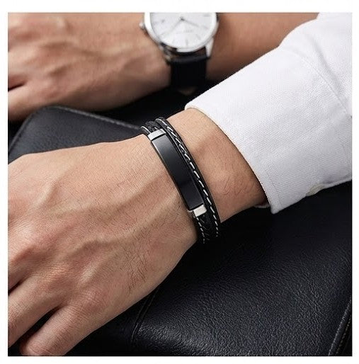 Close-up of a person's wrist wearing a black leather bracelet with a white shirt sleeve.